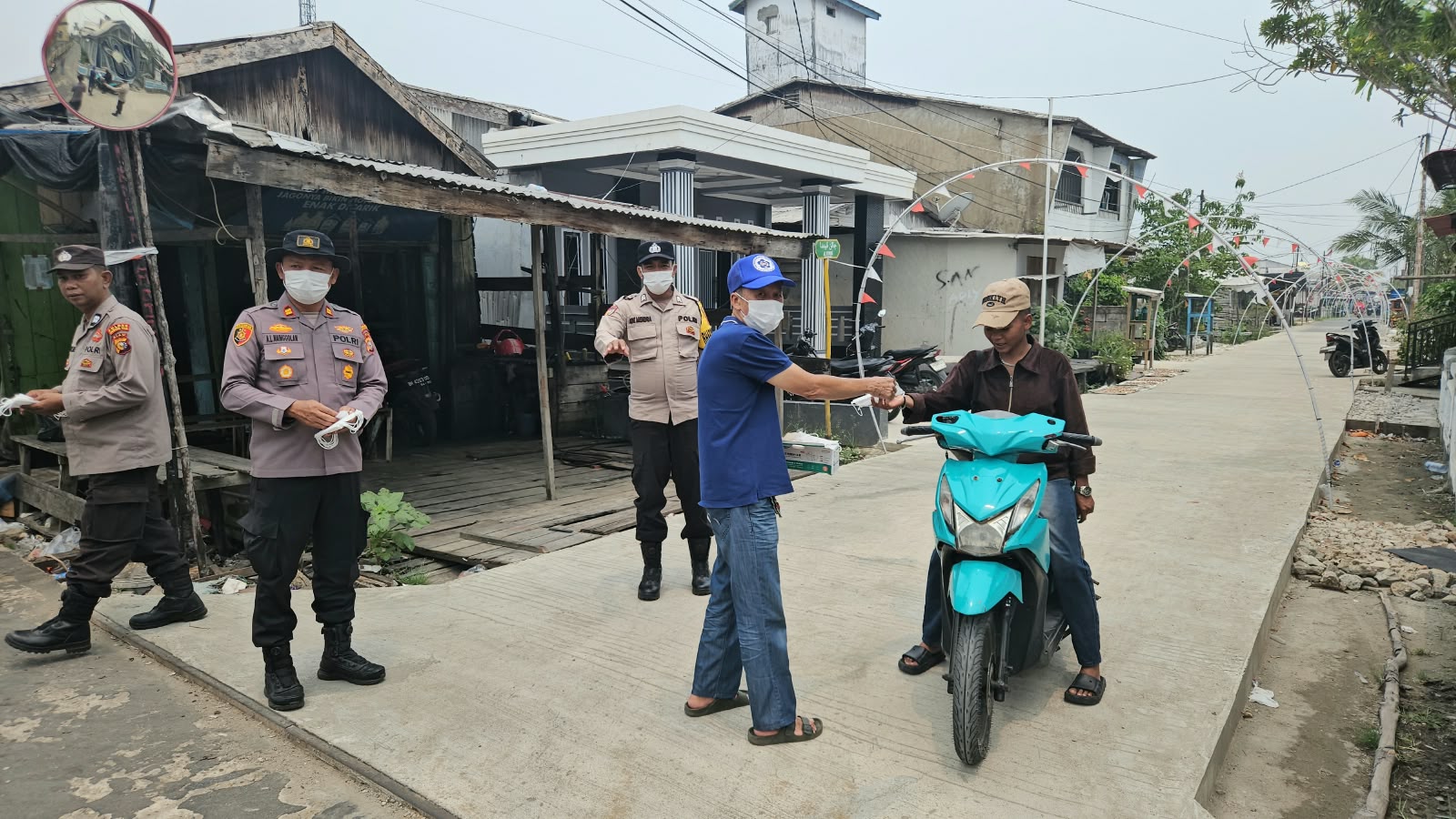 Peduli Kabut Asap, PSMTI dan Polsek Tanah Merah Bagikan 100 Masker ke Warga
